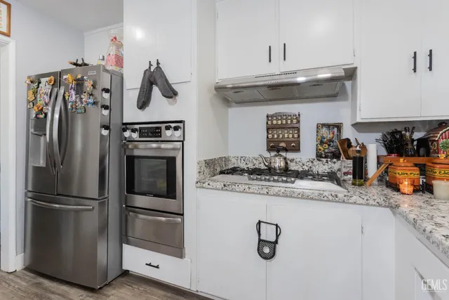 a kitchen with stainless steel appliances granite countertop a refrigerator and a stove top oven