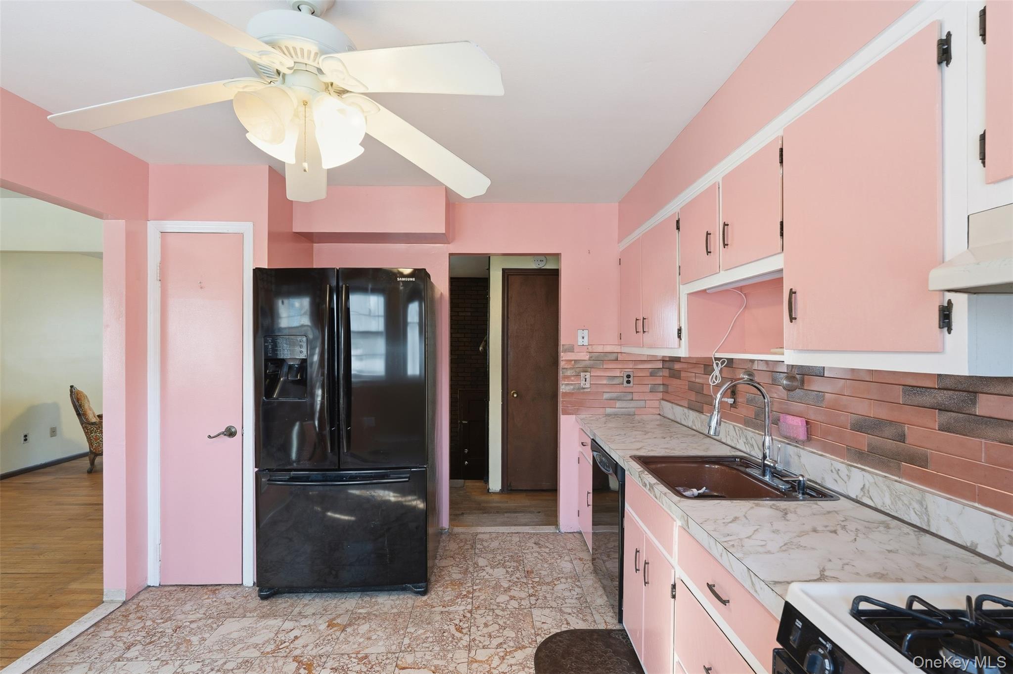 563 Union Road Spring Valley, NY 10977 - Photo 2 of 16 Kitchen featuring a ceiling fan, black French door refrigerator, brown tiled backsplash, double basin sink with gooseneck faucet, and light-toned countertops