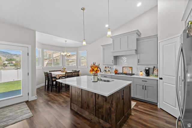 3678 Spiral Springs Road, Unit 204 Tooele, UT 84074 - Photo 13 of 59 Spacious kitchen featuring an expansive center island with countertop seating, wood-finish flooring, light gray cabinetry, and a white subway tile backsplash