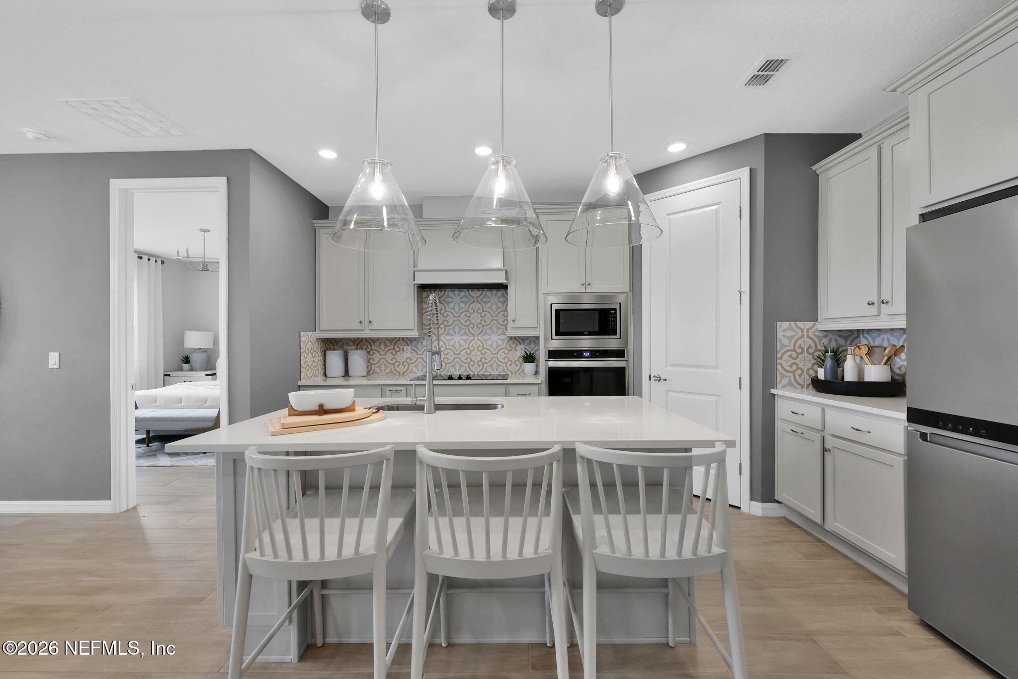 860 Rooster Holw Way Middleburg, FL 32068 - Photo 6 of 26 a kitchen with kitchen island a dining table chairs sink and white appliances