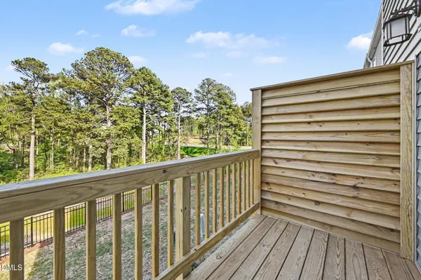 a view of a balcony with wooden floor and fence