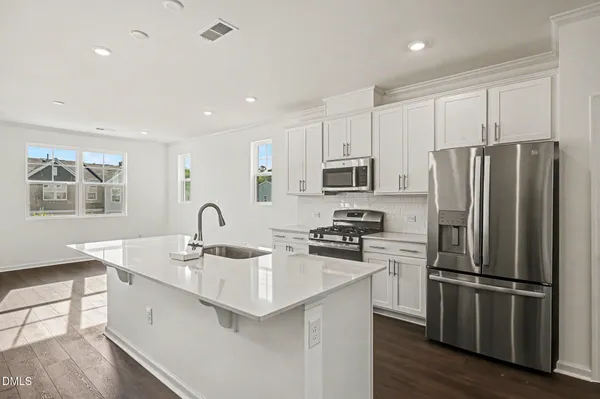 a kitchen with refrigerator cabinets and wooden floor