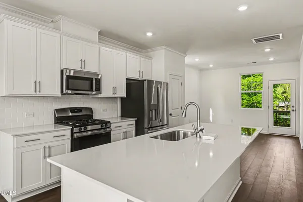 a kitchen with stainless steel appliances a stove sink microwave and cabinets
