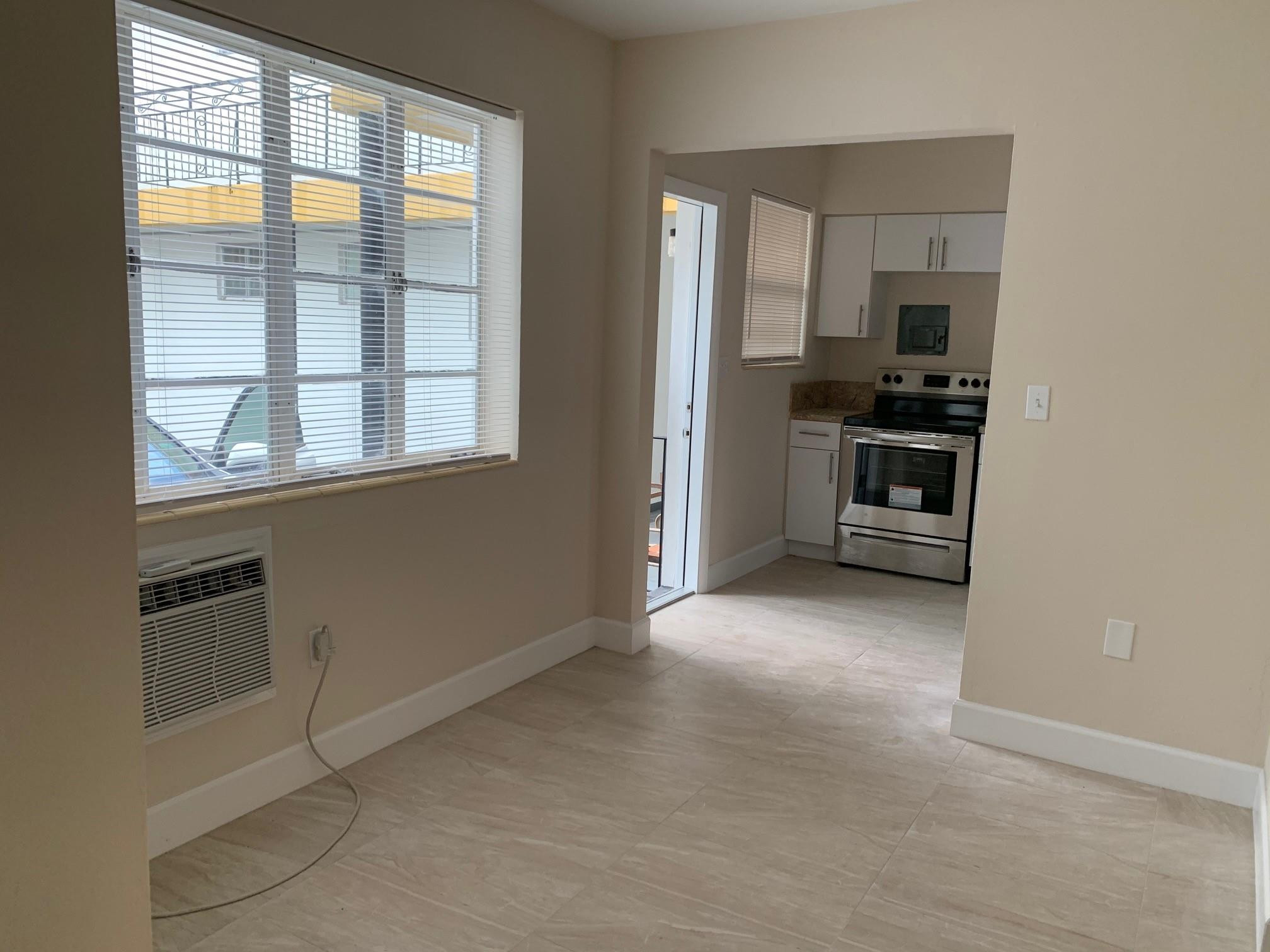 1575 Southwest 2nd Street, Unit 1 Miami, FL 33135 - Photo 5 of 10 an empty room with windows and refrigerator