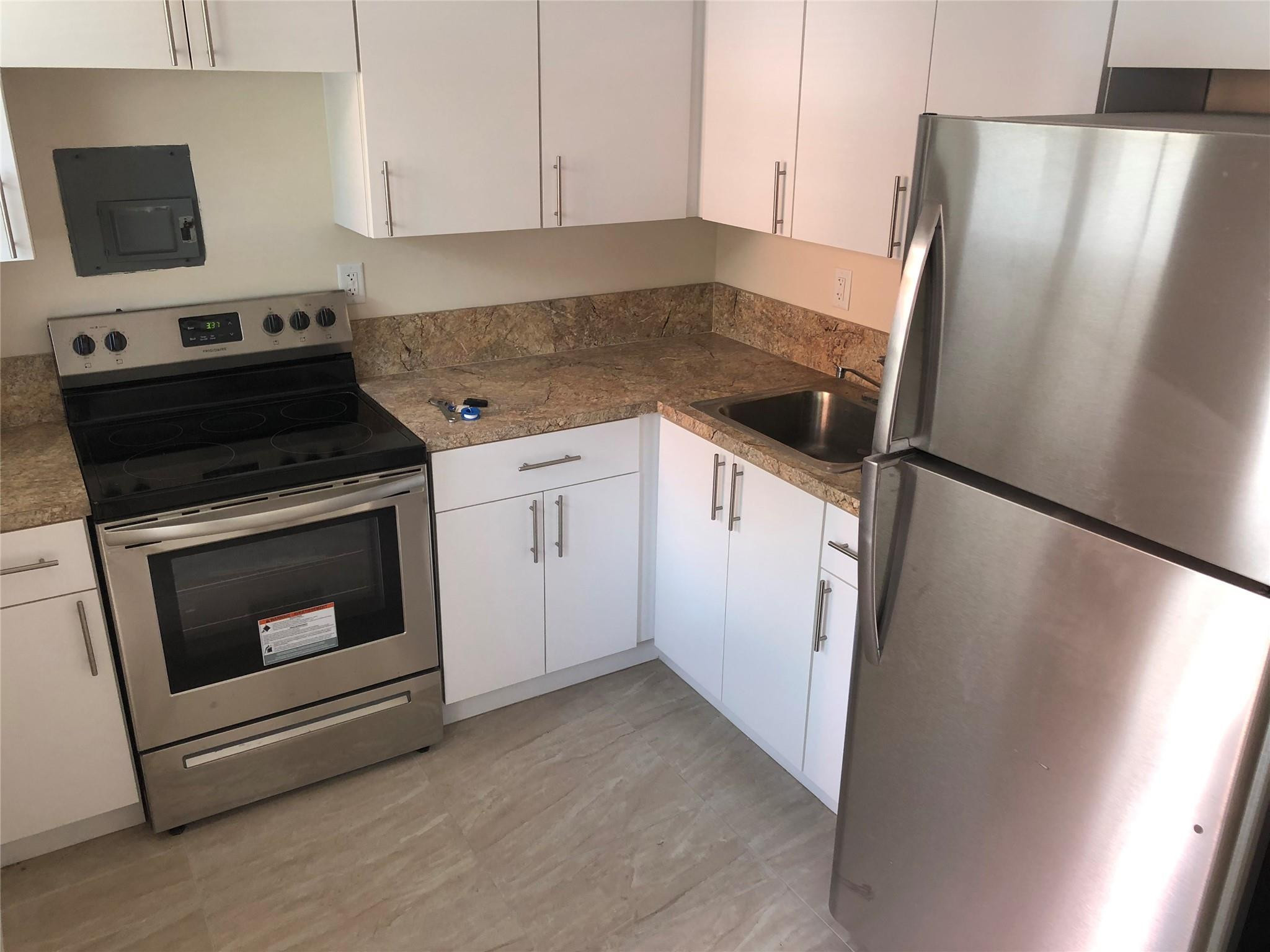 1575 Southwest 2nd Street, Unit 1 Miami, FL 33135 - Photo 7 of 10 a kitchen with a stove microwave and refrigerator