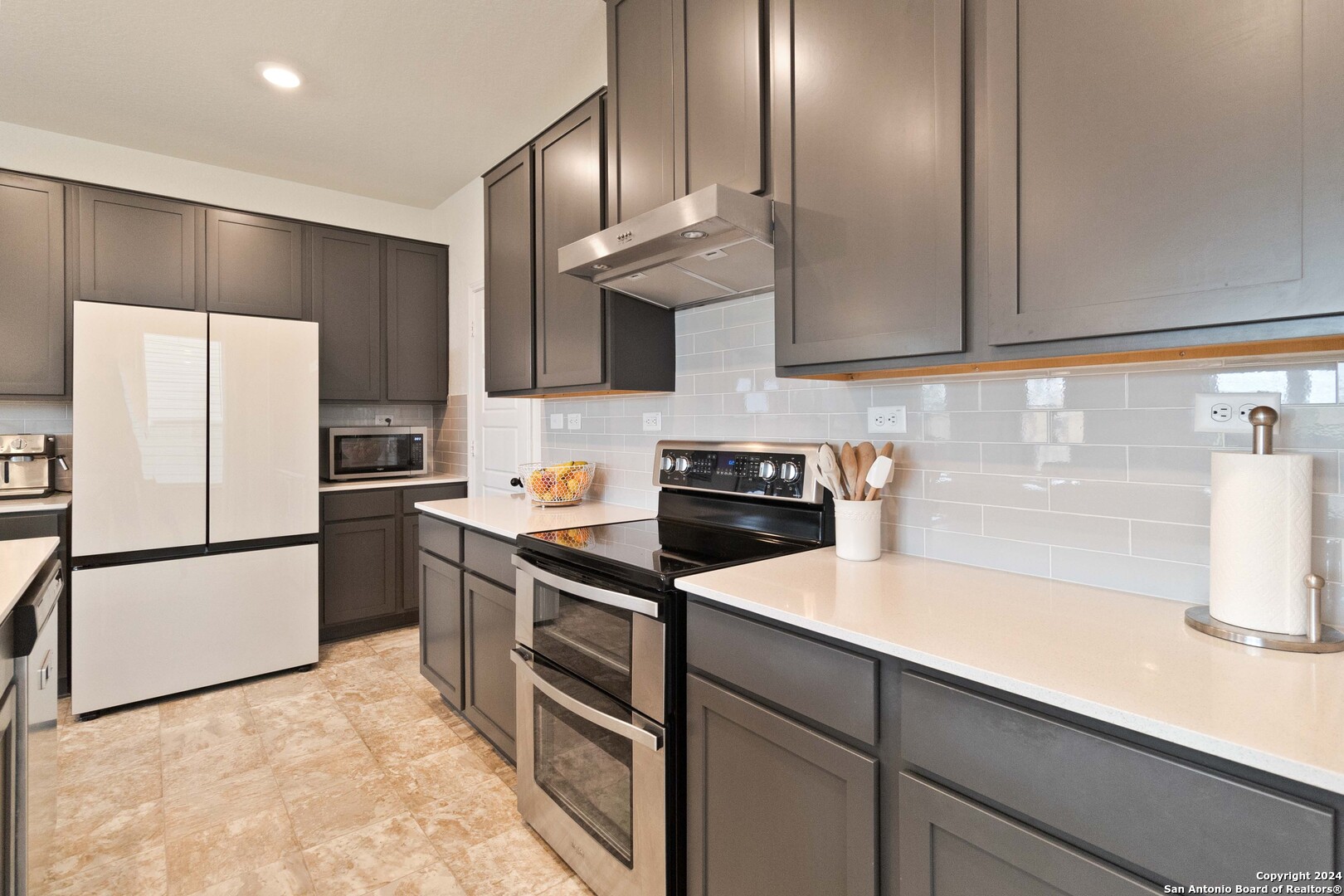 6611 Runaway Row Converse, TX 78109 - Photo 12 of 30 a kitchen with a sink a refrigerator and cabinets