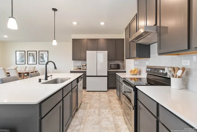 a kitchen with a sink refrigerator and cabinets