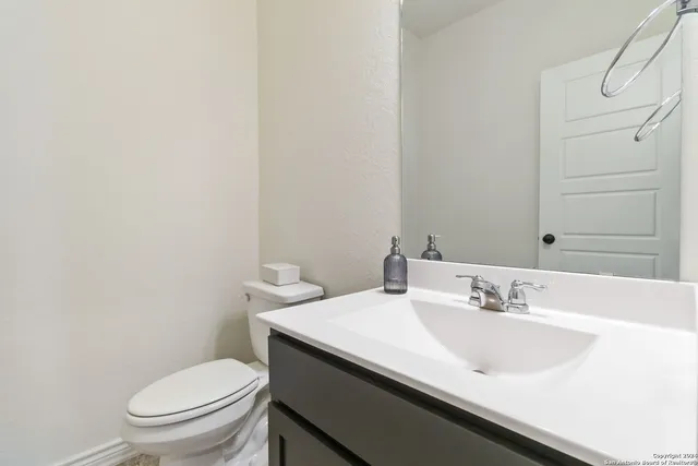 a bathroom with a sink a toilet and a mirror