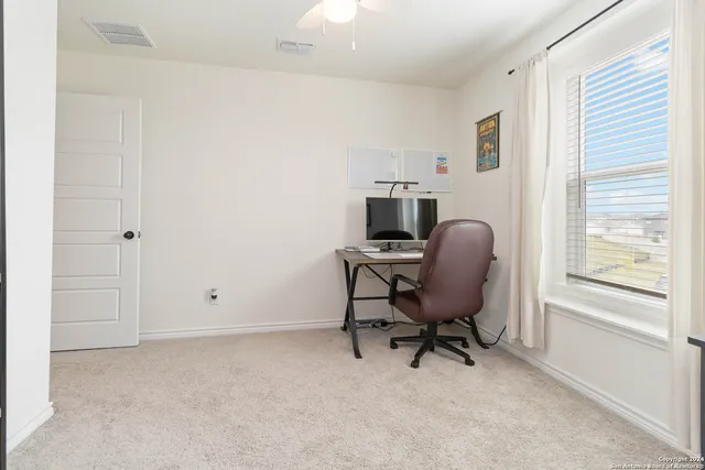a view of a workspace with furniture and a window