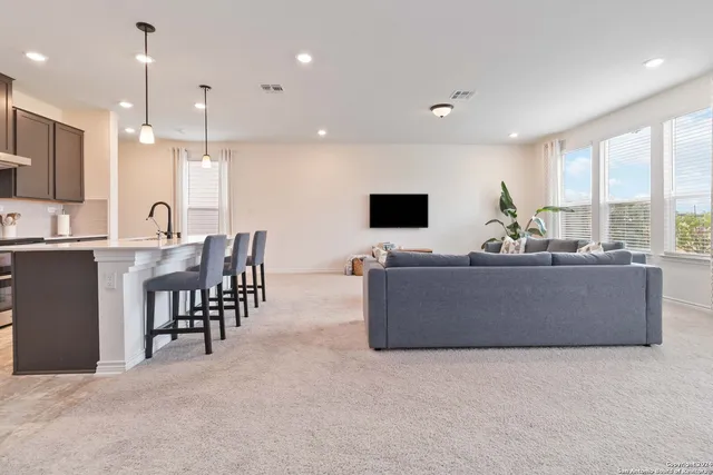 a living room with furniture a flat screen tv and a large window