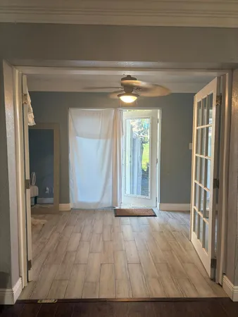 a view of a room with wooden floor and a window