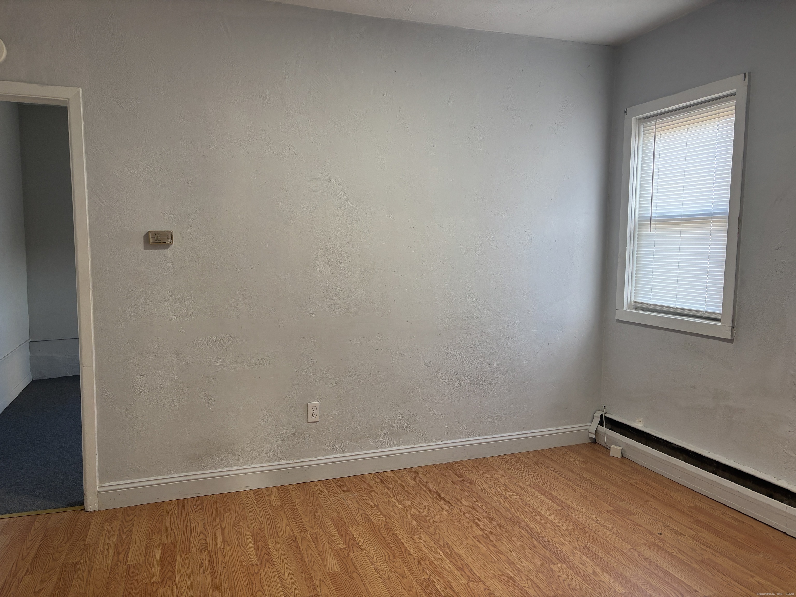 55 Bouton Street, Unit 1 Norwalk, CT 06854 - Photo 5 of 12 a view of an empty room with wooden floor and a window