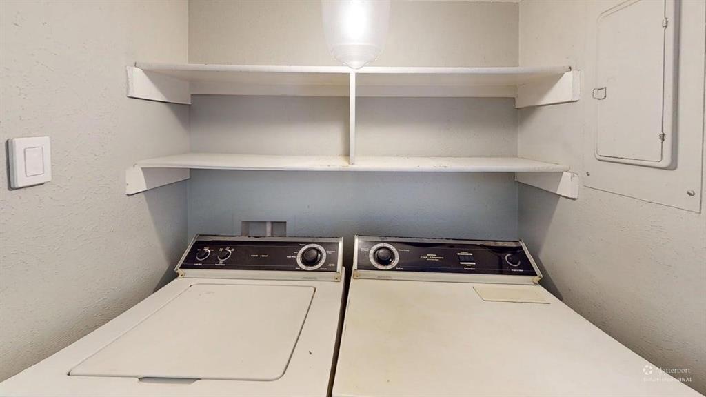 4531 North O'Connor Road, Unit 1196 Irving, TX 75062 - Photo 11 of 14 Laundry area featuring electric panel, a textured wall, and washing machine and dryer
