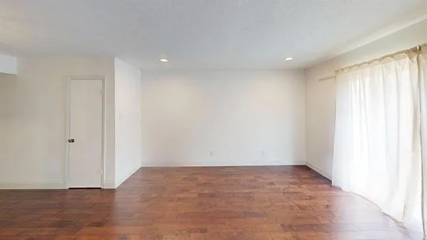 a view of room with window and wooden floor