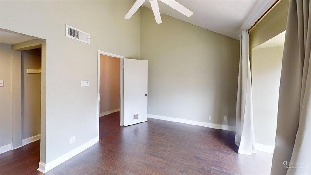 4531 North O'Connor Road, Unit 1196 Irving, TX 75062 - Photo 8 of 14 Unfurnished bedroom featuring lofted ceiling, dark wood finished floors, and ceiling fan