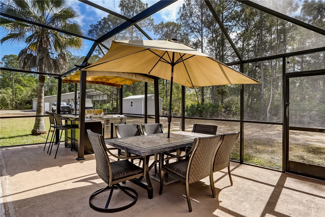 96356 Chester Road Yulee, FL 32097 - Photo 30 of 34 a view of patio with table and chairs under an umbrella