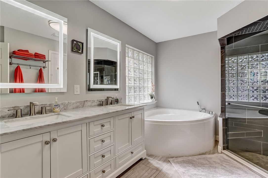 96356 Chester Road Yulee, FL 32097 - Photo 4 of 34 a bathroom with a double vanity sink a mirror and a bathtub