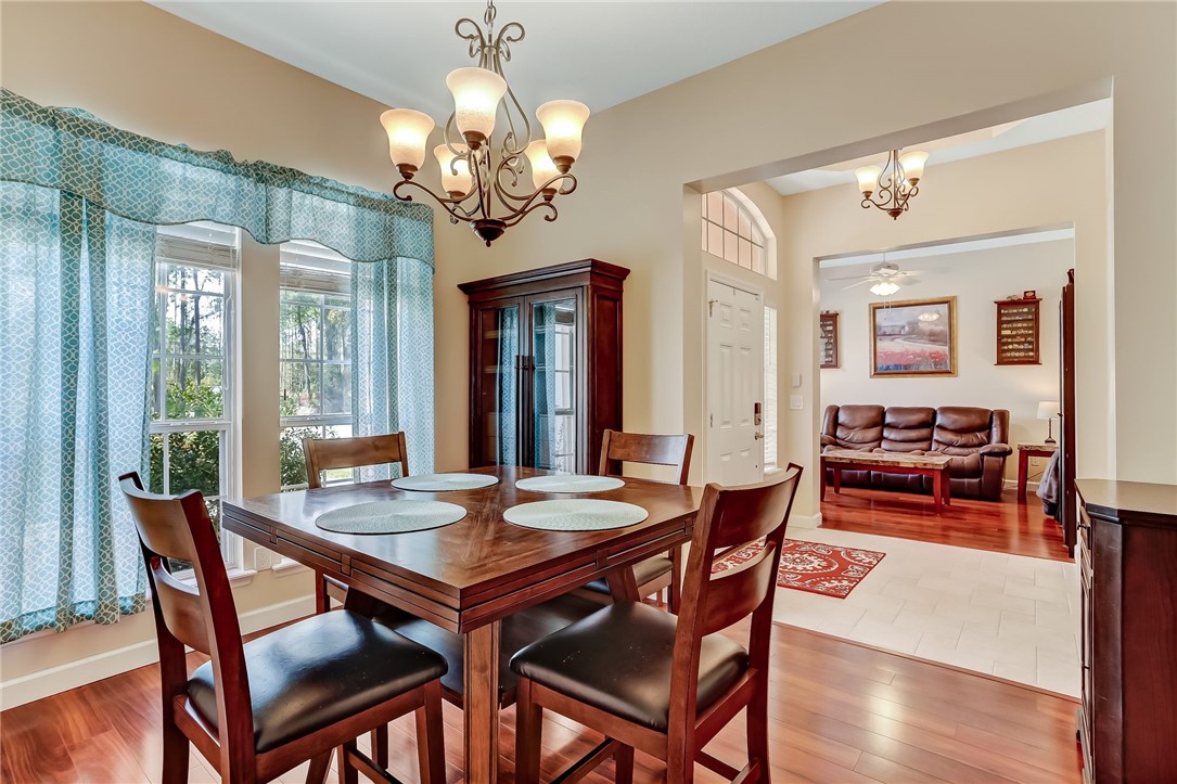 96356 Chester Road Yulee, FL 32097 - Photo 10 of 34 a view of a dining room with furniture wooden floor and chandelier