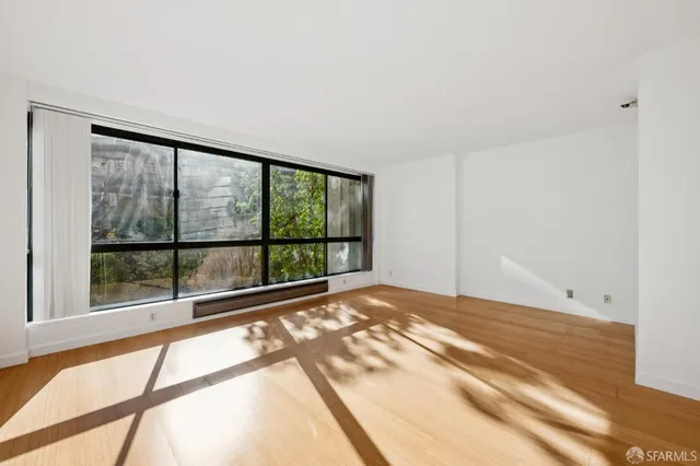 a view of a bedroom with wooden floor and kitchen