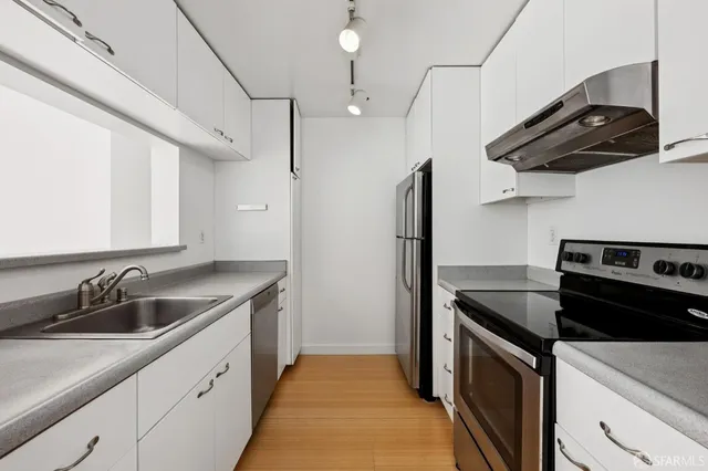 a kitchen with stainless steel appliances granite countertop a stove and a refrigerator