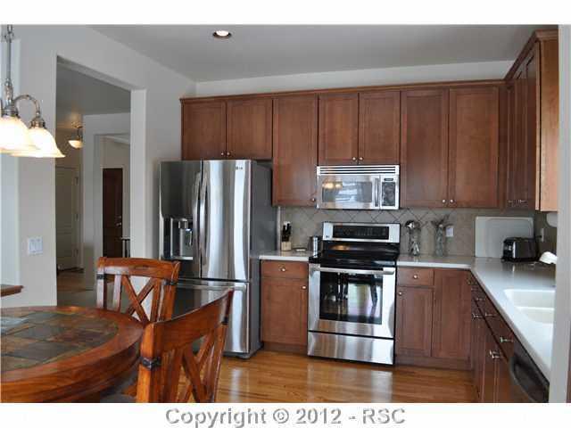 2844 Cinnabar Road Colorado Springs, CO 80921 - Photo 2 of 16 The kitchen is the heart of the home, stainless appliances, Upgraded cabinetry, hardwood flooring, corian counters and walks out to the rear patio