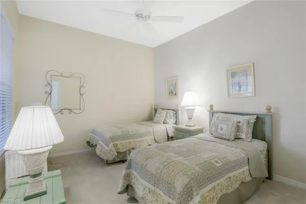 a bedroom with two beds and lamp