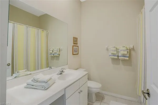 a bathroom with a sink and mirror with toilet