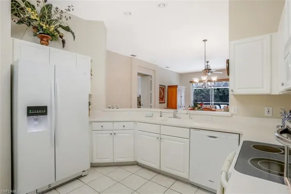 a kitchen with white cabinets and white appliances