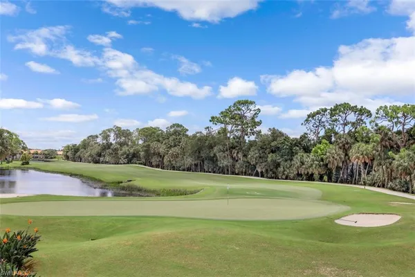 a view of a swimming pool with a lawn chairs under an umbrella