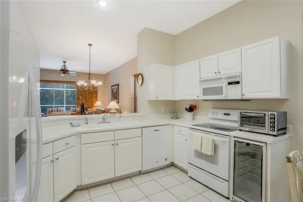 a kitchen with white cabinets appliances and a sink