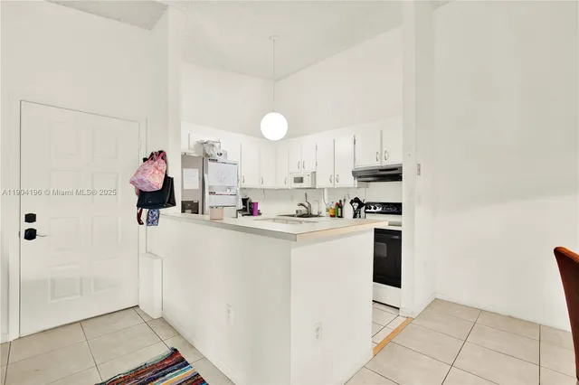 a kitchen with white cabinets and white appliances