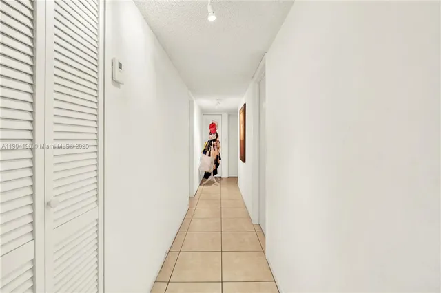 a hallway with wooden floor and a potted plant