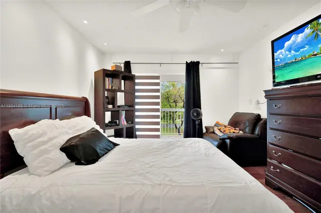 a bedroom with a large bed and flat tv screen