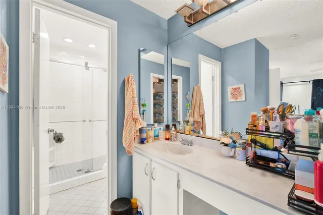 a bathroom with a sink mirror and a shower
