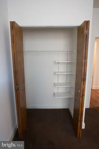 a view of walk in closet with empty racks
