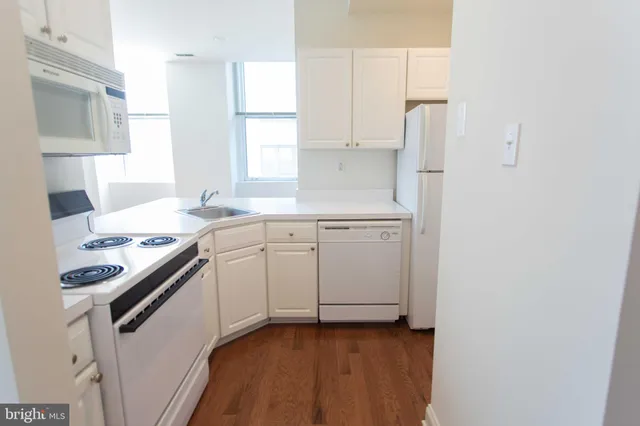 a kitchen with a sink stove and white cabinets