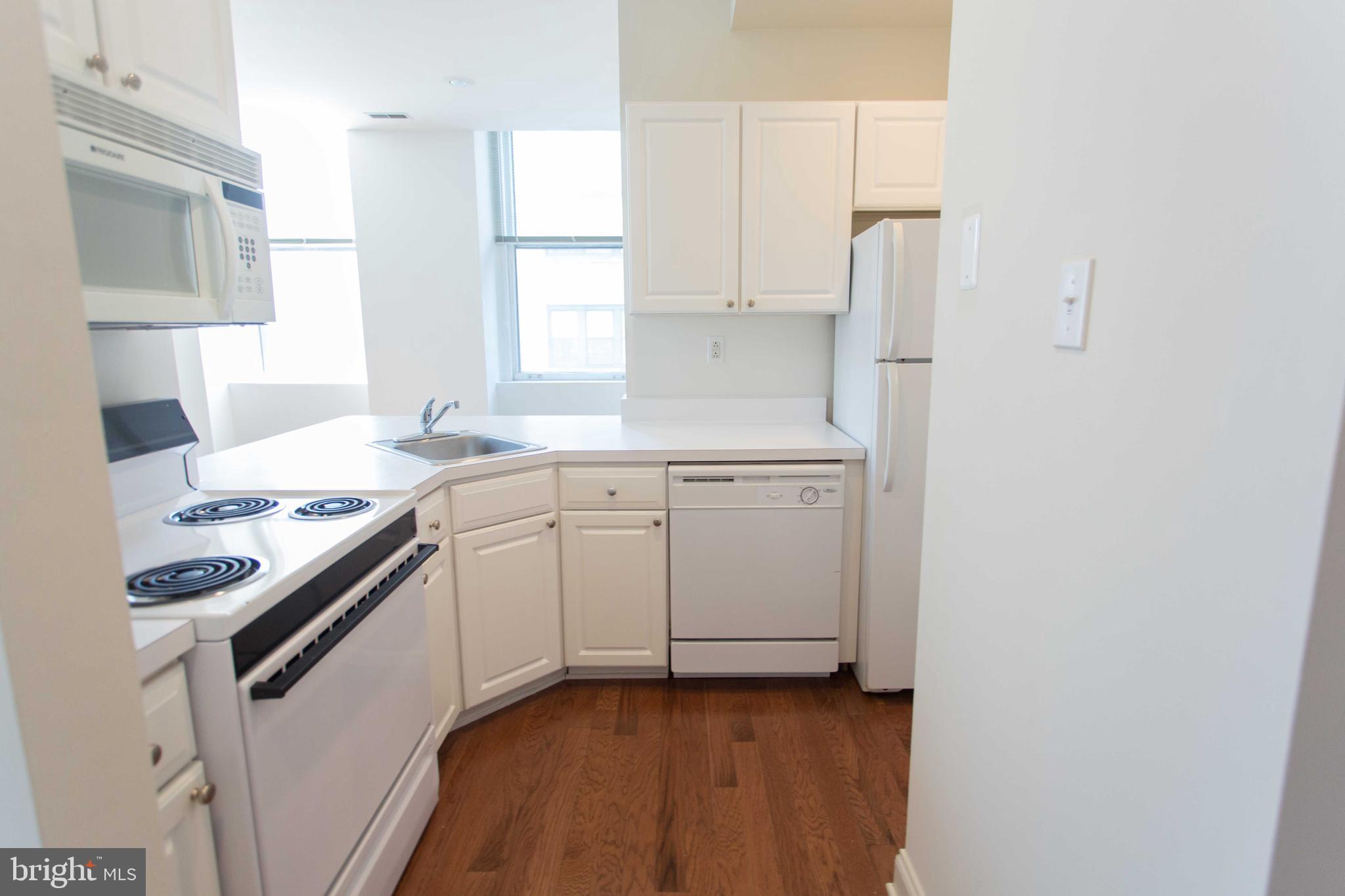 1411-3 Walnut Street, Unit 506 Philadelphia, PA 19102 - Photo 20 of 23 a kitchen with a sink stove and white cabinets