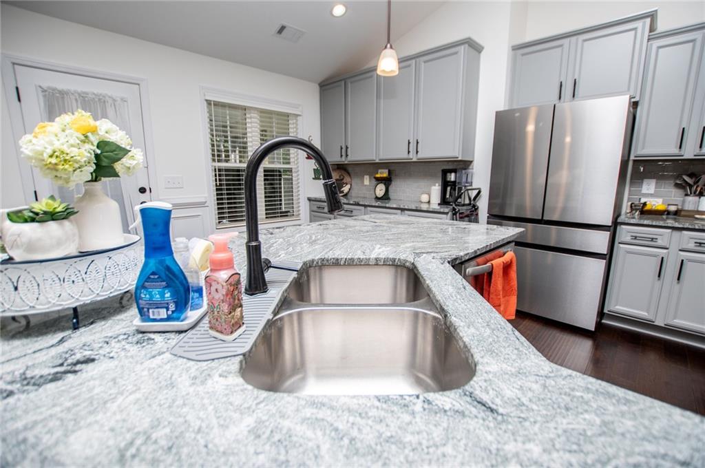 142 Lawrence Drive Villa Rica, GA 30180 - Photo 22 of 80 a kitchen with stainless steel appliances granite countertop a refrigerator sink and wooden cabinets