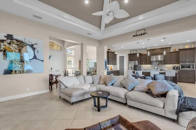 a living room with furniture kitchen view and a chandelier