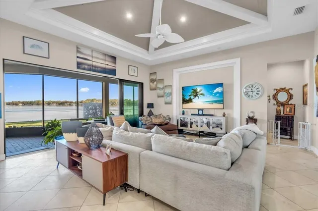 a living room with furniture ceiling fan and a floor to ceiling window