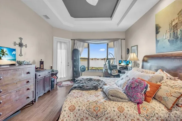 a bedroom with a bed and wooden floor