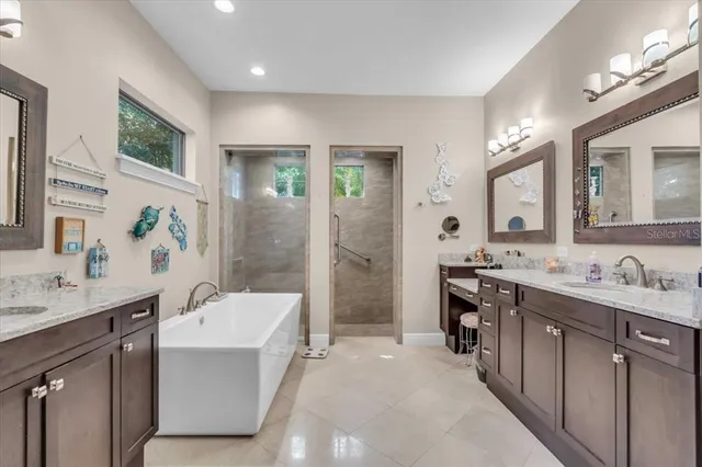 a spacious bathroom with a bathtub sink double and mirror