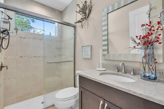 a bathroom with a granite countertop sink a toilet and shower