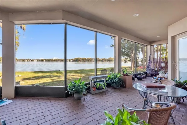 a living room with furniture and floor to ceiling windows