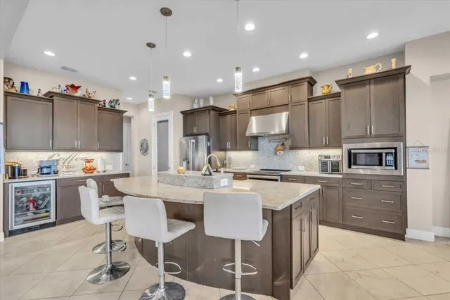 a kitchen with kitchen island a stove a table and chairs in it