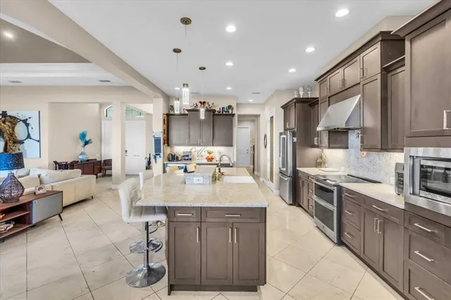 a large kitchen with kitchen island a sink stainless steel appliances and cabinets