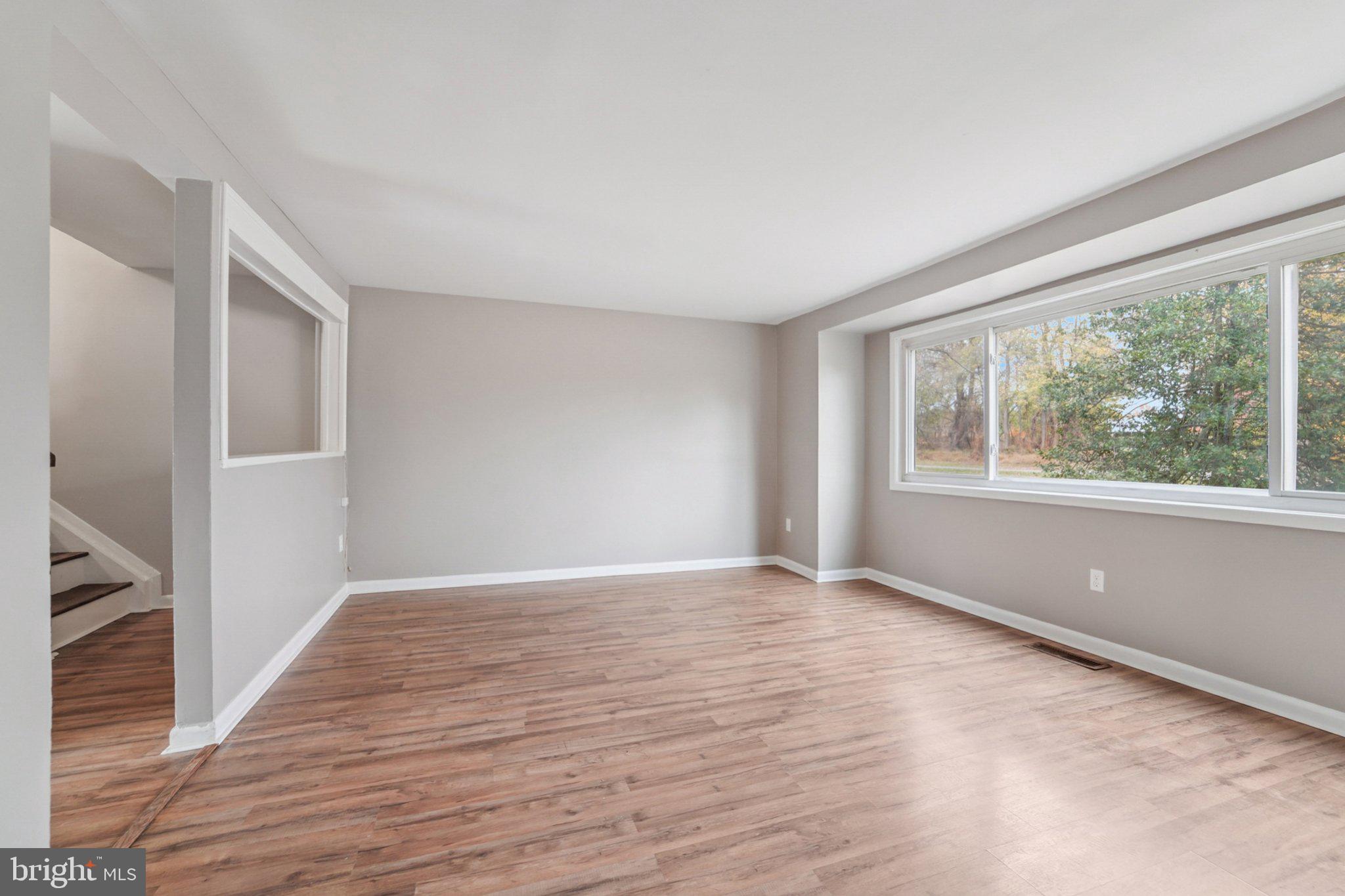 9432 Merryrest Road, Unit AB Columbia, MD 21045 - Photo 26 of 37 a view of an empty room with wooden floor and a window
