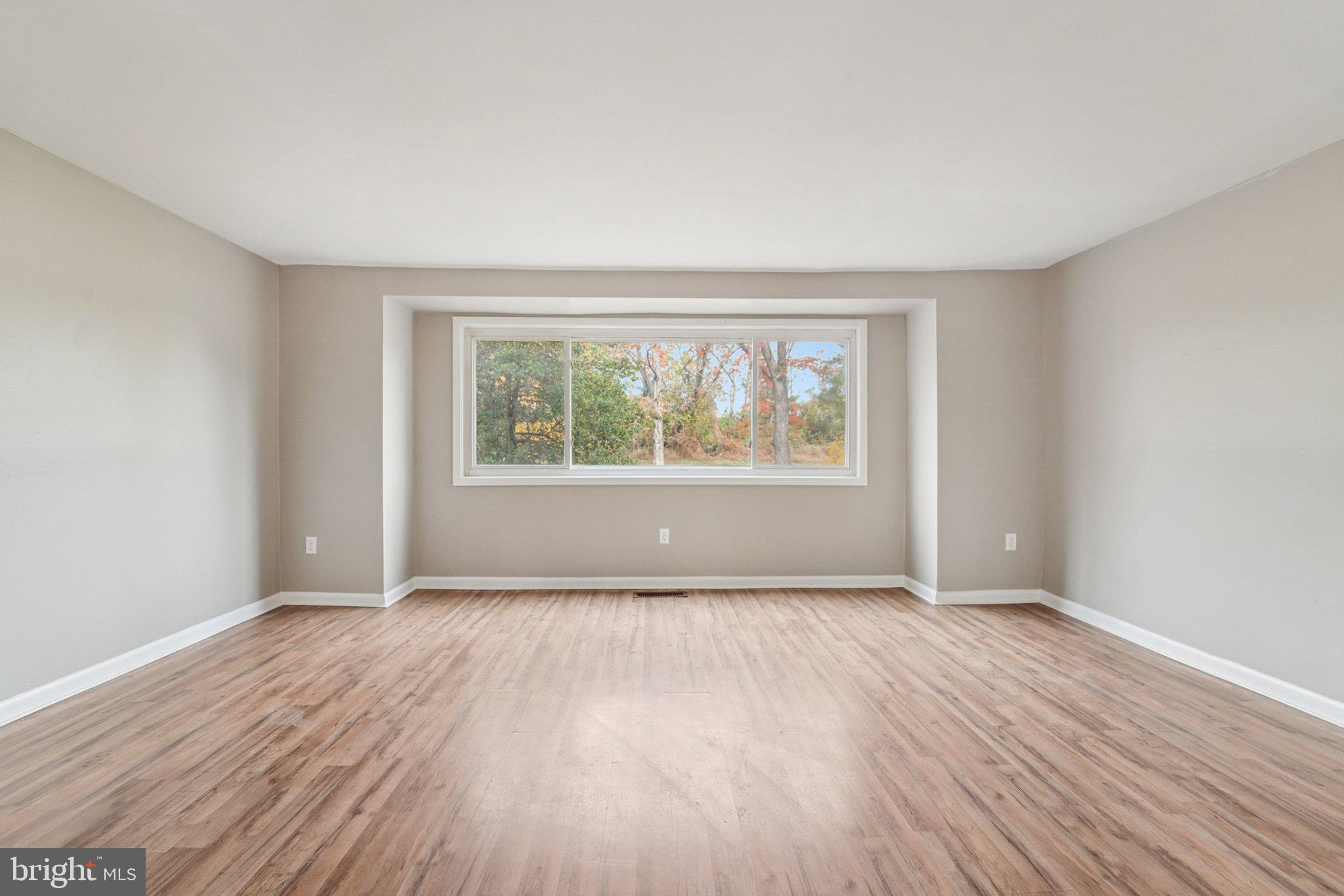 9432 Merryrest Road, Unit AB Columbia, MD 21045 - Photo 3 of 37 an empty room with wooden floor and windows