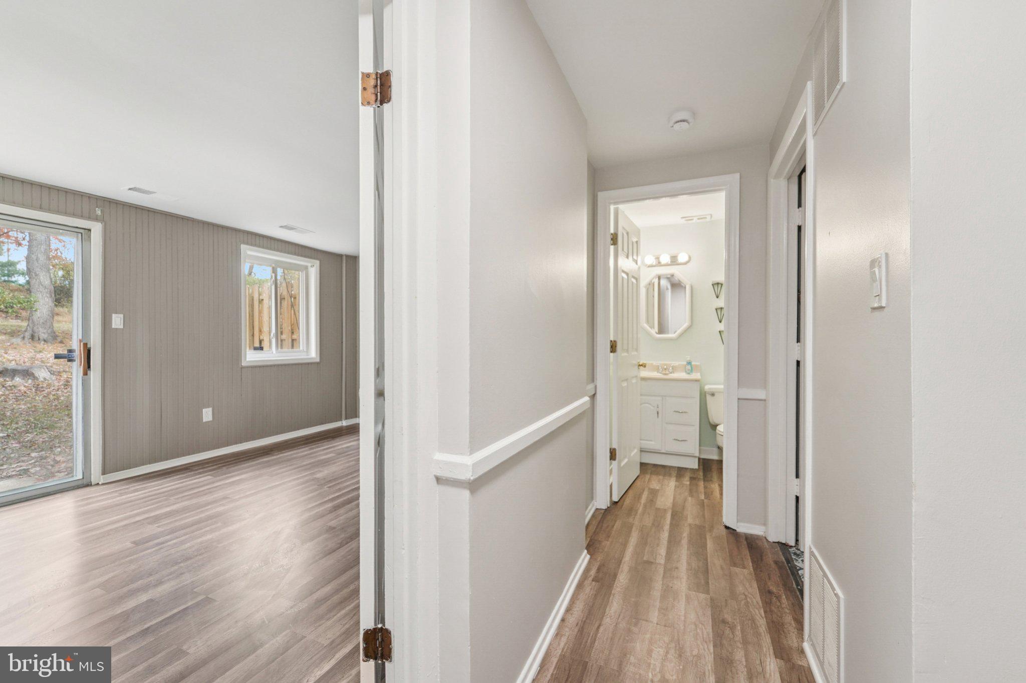 9432 Merryrest Road, Unit AB Columbia, MD 21045 - Photo 32 of 37 a view of a hallway with wooden floor and a bathroom