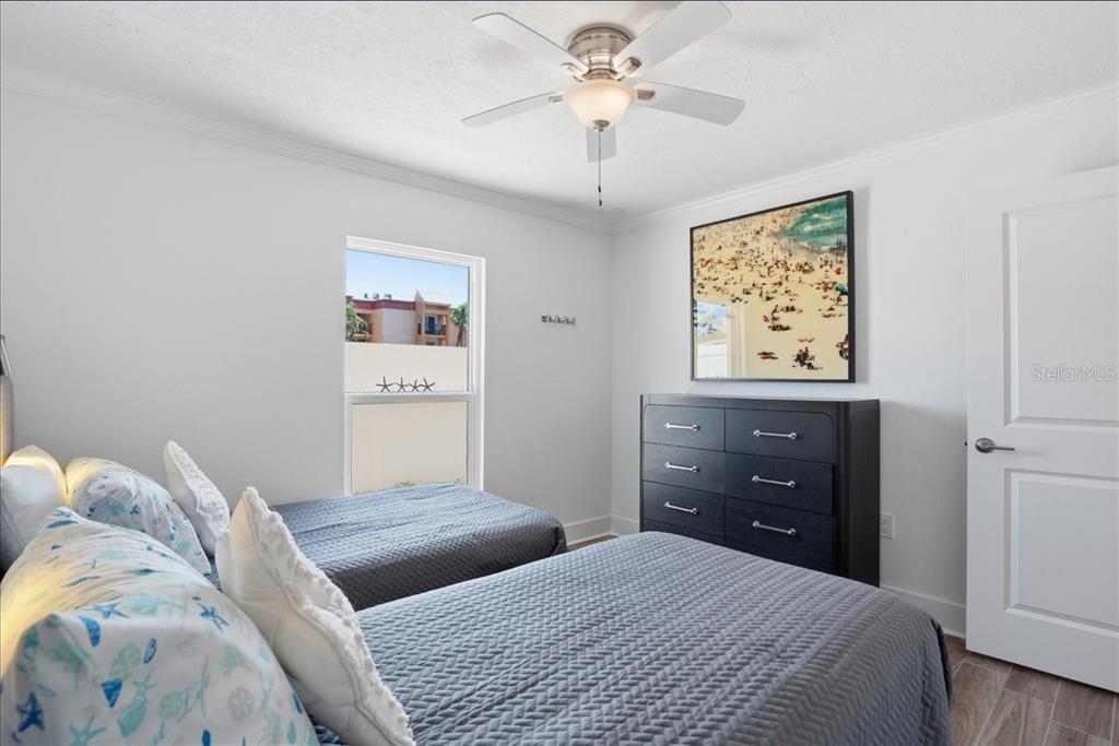 8911 Blind Pass Road, Unit 118 St. Pete Beach, FL 33706 - Photo 27 of 34 a bedroom with a bed and a painting on the wall